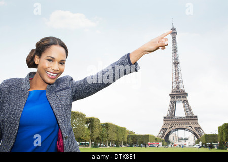 Woman posing as if to touch Eiffel Tower, Paris, France Stock Photo