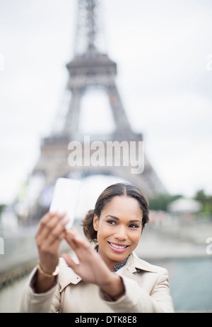 Woman taking self-portrait in front of Eiffel Tower, Paris, France Stock Photo