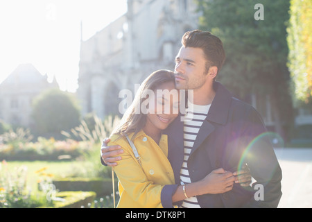 Couple hugging in urban park Stock Photo