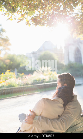 Couple hugging on park bench Stock Photo