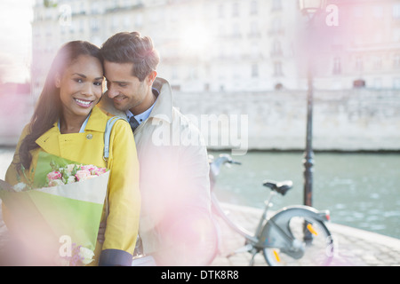 Couple with bouquet of flowers by Seine River, Paris, France Stock Photo