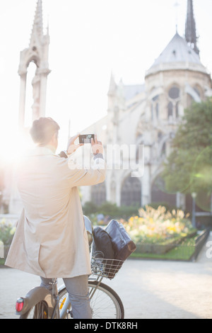 Man photographing Notre Dame Cathedral, Paris, France Stock Photo