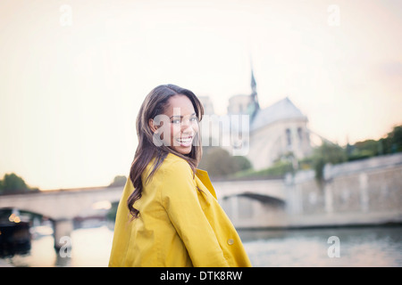 Woman smiling along Seine River near Notre Dame Cathedral, Paris, France Stock Photo