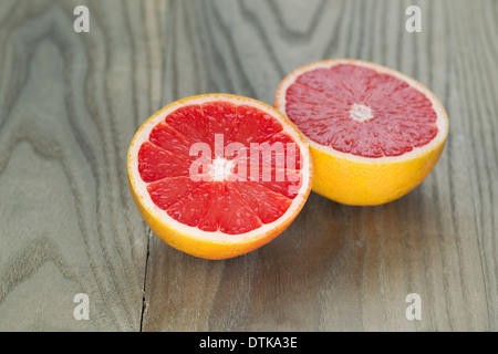 Horizontal photo of sliced ruby red grapefruit on aged wood Stock Photo