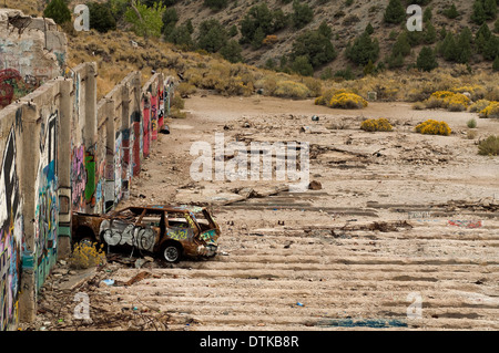 An abandoned car near an old mining complex Stock Photo