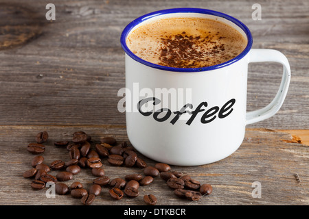 https://l450v.alamy.com/450v/dtkbcr/enamel-mugs-with-hot-coffee-and-coffee-beans-on-a-rustic-wooden-board-dtkbcr.jpg