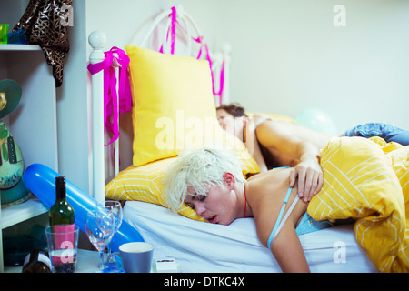 Couple sleeping in bed the morning after a party Stock Photo