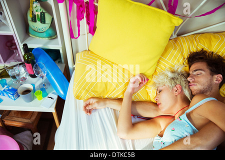 Couple sleeping in bed after party Stock Photo