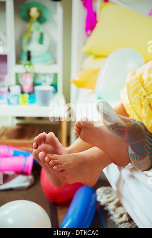 Couple's feet sticking out from bed covers Stock Photo