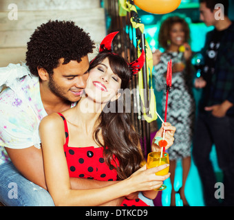 Man hugging girlfriend at party Stock Photo