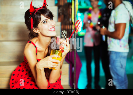 Woman wearing devil costume at party Stock Photo