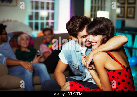 Couple hugging in living room at party Stock Photo