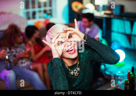 Woman making face in living room at party Stock Photo