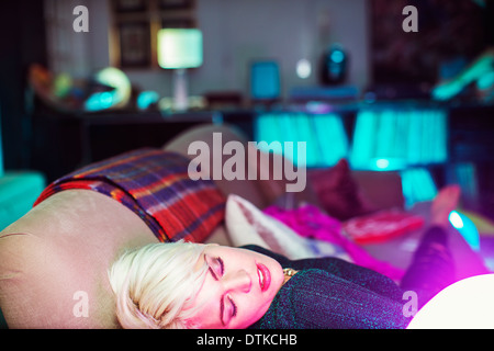 Woman sleeping on sofa after party Stock Photo