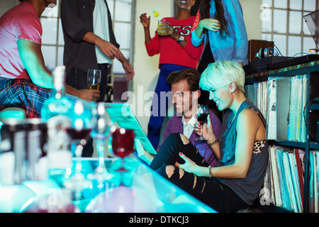 Couple looking at records at party Stock Photo