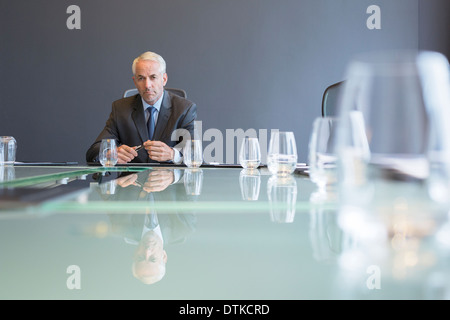 Businessman sitting at meeting table Stock Photo