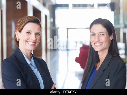 Businesswomen smiling in lobby Stock Photo