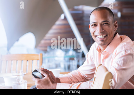 Businessman using cell phone in office Stock Photo