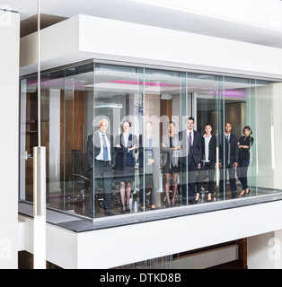 Business people standing at window of modern conference room Stock Photo