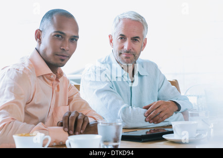 Businessmen using digital tablet in cafe Stock Photo