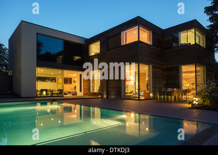 Modern house and swimming pool illuminated at dusk Stock Photo