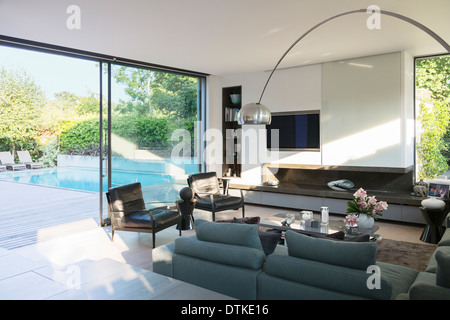 Modern living room overlooking patio with swimming pool Stock Photo