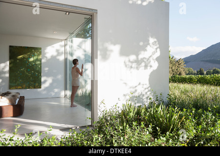 Woman standing at window in modern house