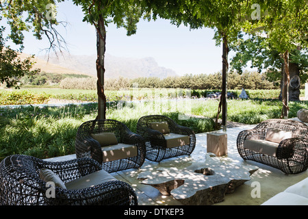 Armchairs and sofa on modern patio overlooking vineyard Stock Photo