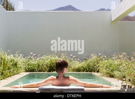 Woman relaxing in luxury lap pool Stock Photo