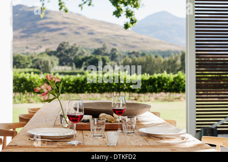 Dining table and chairs on luxury patio overlooking vineyard Stock Photo