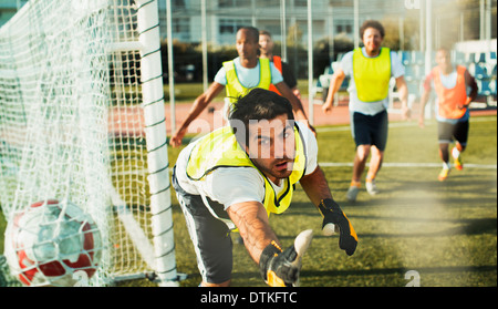 Goalie training on soccer field Stock Photo