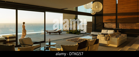 Woman walking on modern patio overlooking ocean Stock Photo