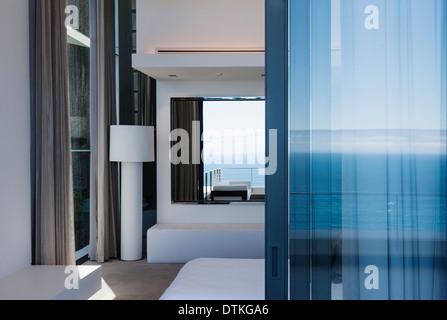 Glass door and windows of modern house overlooking ocean Stock Photo