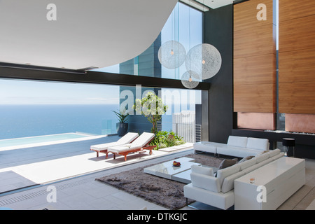 Living room and patio of modern house overlooking ocean Stock Photo