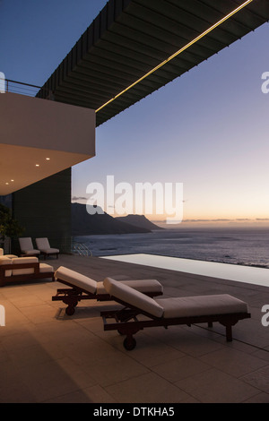 Balcony of modern house overlooking ocean at sunset Stock Photo