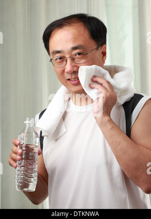 Asian man after exercise with towel and a bottle of water Stock Photo