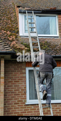 Roofer workman repairing storm damage to a tiled roof tools Stock Photo