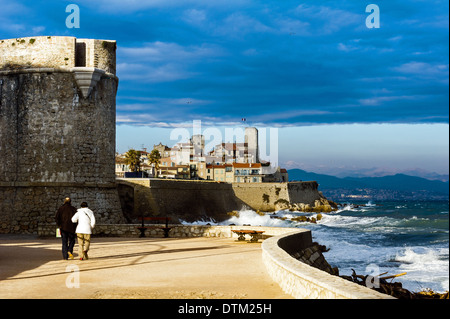 Europe, France, Alpes-Maritimes, Antibes. Old town walls. Aged couple walking. Stock Photo