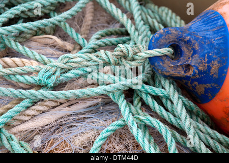 Old fishing buoy with green rope and fishing net Stock Photo