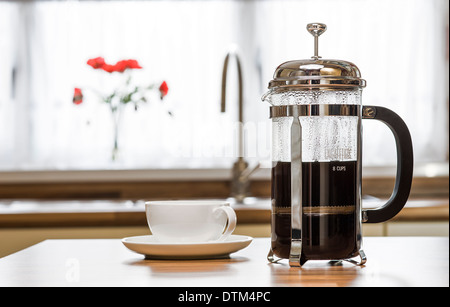 Cafetiere with cup and saucer on a kitchen worktop. Stock Photo