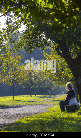 Lady relaxes to earlier hour in the wild, Stock Photo