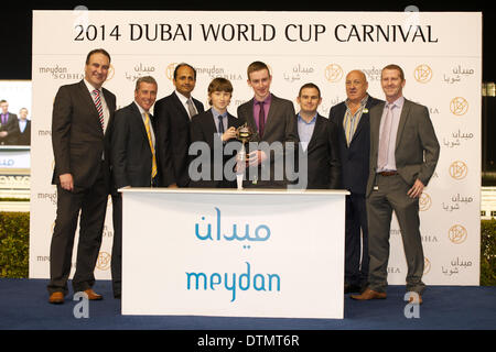 Meydan Racecourse, Dubai, UAE. 20th Feb 2014. The owners of Elleval collect their trophy after Race 5 of the 7th Meeting of the Dubai World Cup Carnival at Meydan Racecourse Credit:  Tom Morgan/Alamy Live News Stock Photo