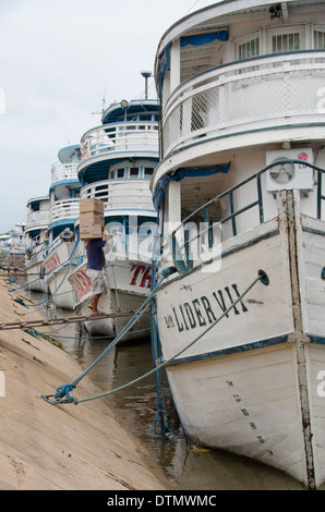 Brazil, Amazonas, Rio Tapajos, Santarem. Loading cargo onto typical Amazon boats at the port area of Santarem. Stock Photo