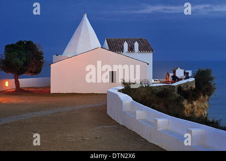 Portugal, Algarve, Armacao de Pera, Porches, Nossa Senhora da Rocha, chapel, rock, sea, ocean, small sanctuary, fishermen, chapel on a rock, sea view, night, evening, illumination, travel, tourism, sightseeing, highlights of the Algarve, nature, erosion, r Stock Photo