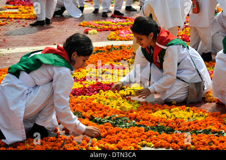 Dhaka, Bangladesh. 21st Feb 2014.  Volunteers decorate Language Martyrs Memorial monument with flowers during the International Mother Language Day in Dhaka, Bangladesh, Feb. 21, 2014. People pay tributes every year to the language movement martyrs, who sacrificed their lives for establishing Bangla as a state language of then Pakistan in 1952. United Nations Educational, Scientific and Cultural Organization declared Feb. 21 the International Mother Language Day on Nov. 17, 1999 to honor the supreme sacrifice of language martyrs. (Xinhua) Credit:  Xinhua/Alamy Live News Stock Photo