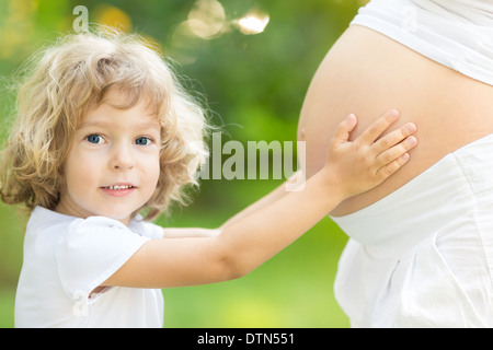 Child holding belly of pregnant woman Stock Photo