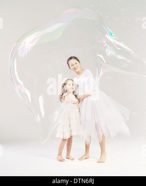 Two sisters with the large soap bubble Stock Photo