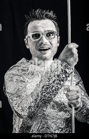 Funny spaceman holding rope. Stock Photo