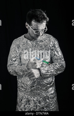 Portrait of spaceman applying syringe. Stock Photo
