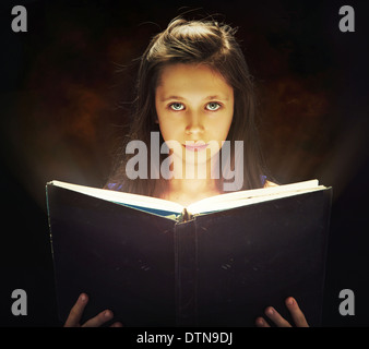 Cute girl opening the magic book Stock Photo